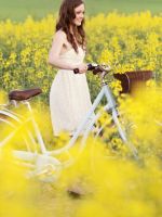 Girl-With-Bicycle-In-Yellow-Field