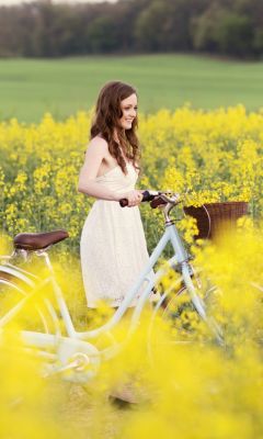 Girl-With-Bicycle-In-Yellow-Field
