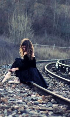 Girl-In-Black-Dress-Sitting-On-Railways
