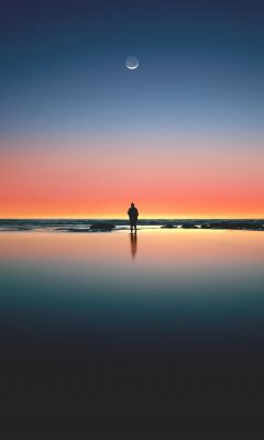 silhouette of man standing on seashore wallpaper