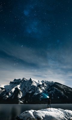 person standing on rock at night wallpaper