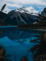 body of water near snow covered mountain during da... wallpaper