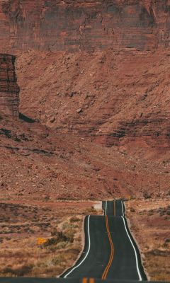 white car on road near brown rock formation during... wallpaper