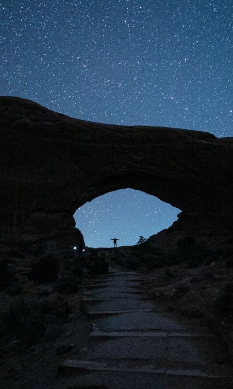 person standing near mountain during nighttime wallpaper